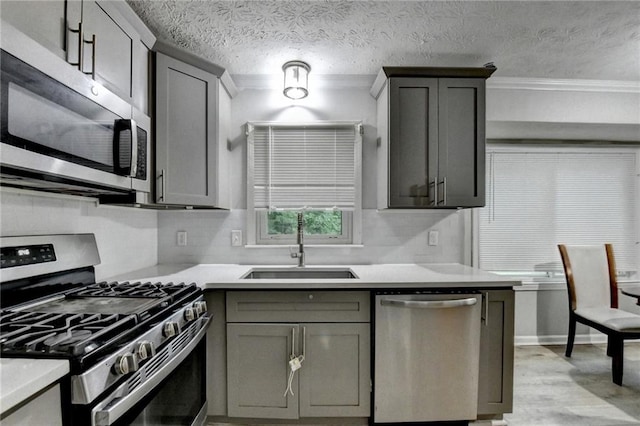 4444 Lisa Way NW, Lilburn, GA 30047 - kitchen with appliances with stainless steel finishes, gray cabinetry, light countertops, crown molding, and light wood-style floors