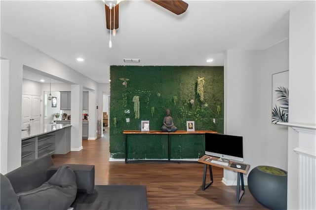 living room with wood finished floors, visible vents, baseboards, recessed lighting, and an accent wall