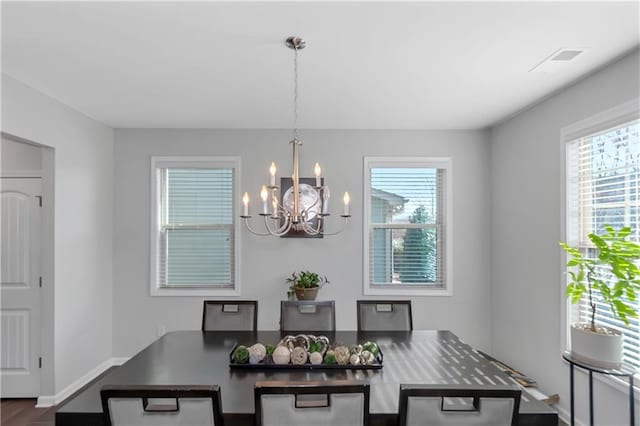 dining area featuring visible vents, baseboards, and a chandelier