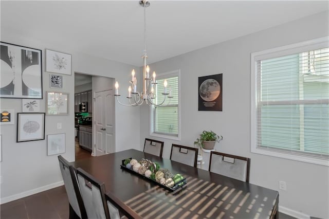 dining room featuring an inviting chandelier and baseboards