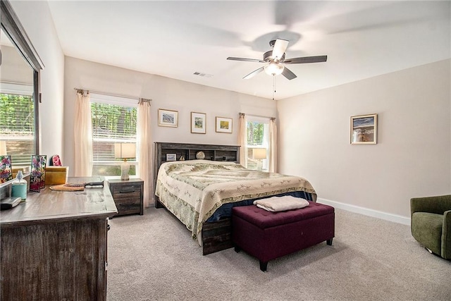 bedroom featuring light carpet, multiple windows, and ceiling fan