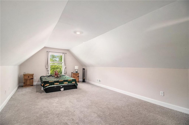 carpeted bedroom with vaulted ceiling and baseboards