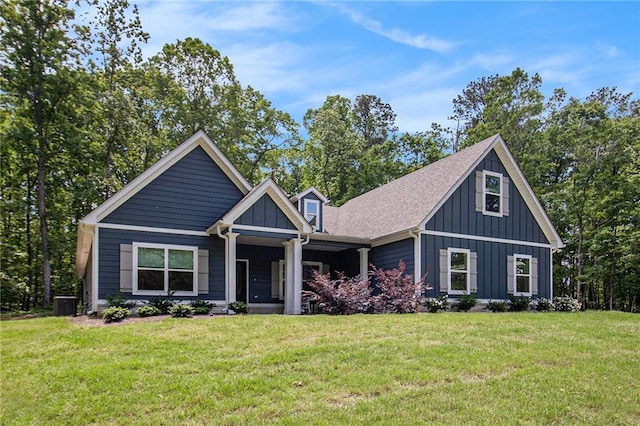 view of front of home with board and batten siding, a front lawn, central AC, and roof with shingles