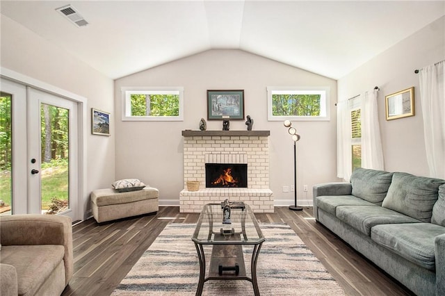 living room featuring a brick fireplace, vaulted ceiling, dark wood-style flooring, and baseboards