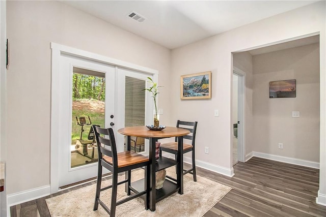 dining space with dark wood finished floors, baseboards, and french doors