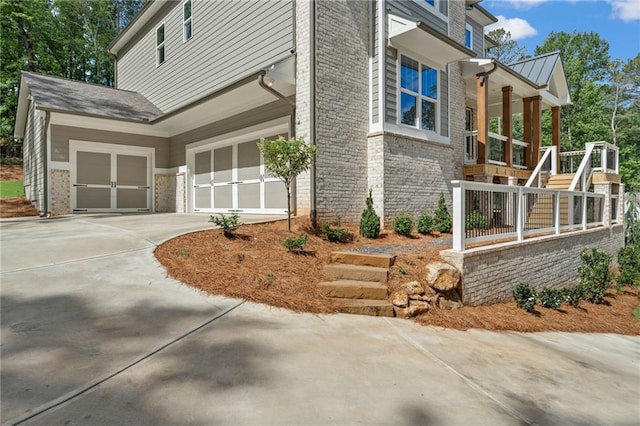 1005 Liberty Springs Dr, Woodstock, GA 30188 - view of home's exterior featuring brick siding, driveway, an attached garage, and stairway