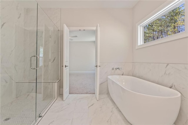 1005 Liberty Springs Dr, Woodstock, GA 30188 - full bath with marble look tiles, a freestanding tub, a marble finish shower, and a wainscoted wall