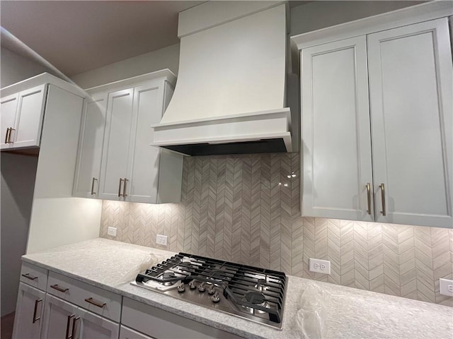 1005 Liberty Springs Dr, Woodstock, GA 30188 - kitchen with premium range hood, stainless steel gas stovetop, white cabinetry, and tasteful backsplash