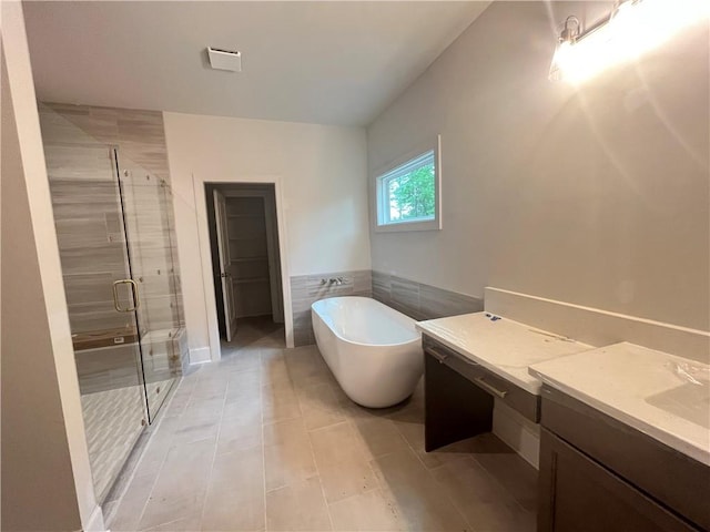 1005 Liberty Springs Dr, Woodstock, GA 30188 - bathroom featuring a freestanding bath, a shower stall, vanity, tile walls, and tile patterned floors