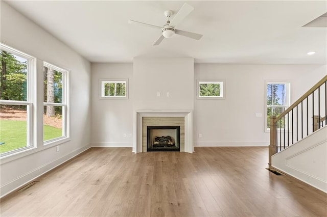 1005 Liberty Springs Dr, Woodstock, GA 30188 - unfurnished living room featuring healthy amount of natural light, stairway, light wood-type flooring, and ceiling fan