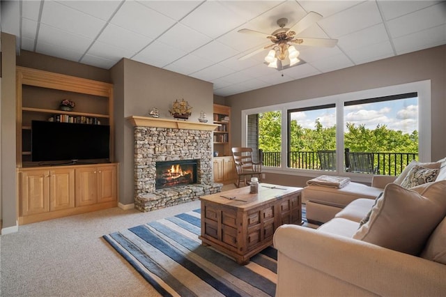711 Wildcat Dr, Big Canoe, GA 30143 - carpeted living room featuring a fireplace, a ceiling fan, a drop ceiling, built in features, and baseboards