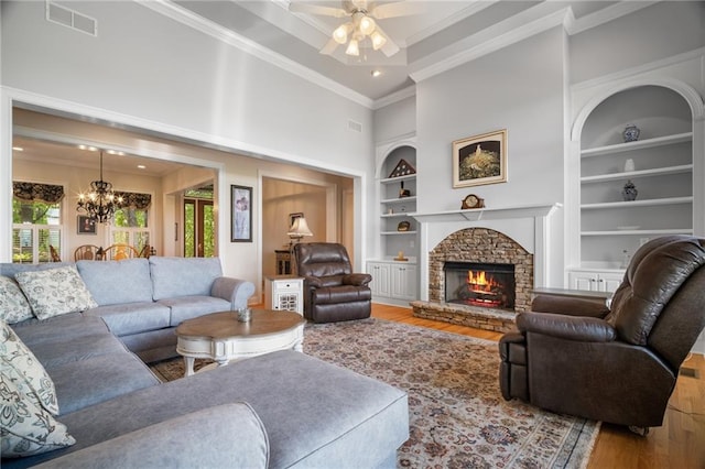711 Wildcat Dr, Big Canoe, GA 30143 - living area with built in shelves, wood finished floors, ornamental molding, a chandelier, and ceiling fan