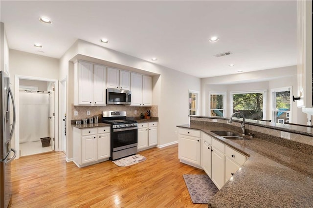 2740 Greymont Ct, Cumming, GA 30041 - kitchen featuring stainless steel appliances, light wood-type flooring, tasteful backsplash, white cabinetry, and recessed lighting