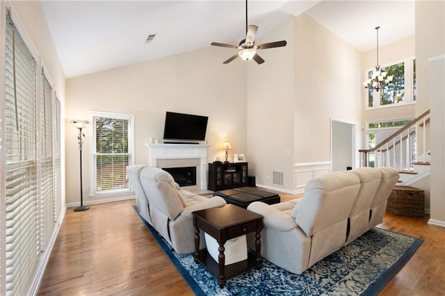 2740 Greymont Ct, Cumming, GA 30041 - living area with high vaulted ceiling, a chandelier, wood finished floors, stairway, and a fireplace