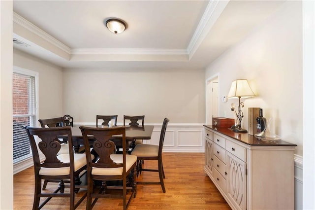 2740 Greymont Ct, Cumming, GA 30041 - dining room with light wood-style flooring, ornamental molding, a raised ceiling, and wainscoting