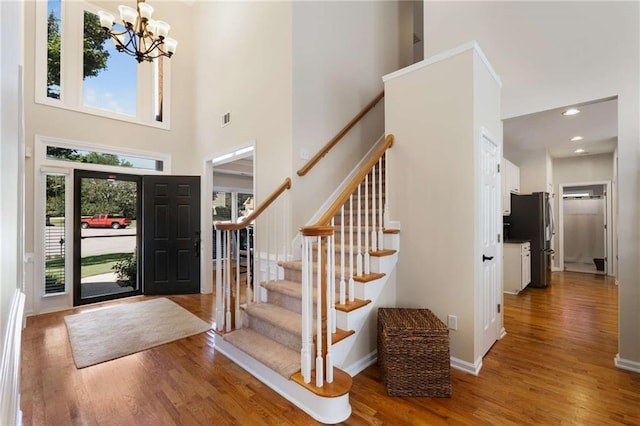 2740 Greymont Ct, Cumming, GA 30041 - entryway with wood finished floors, a chandelier, stairway, a high ceiling, and recessed lighting