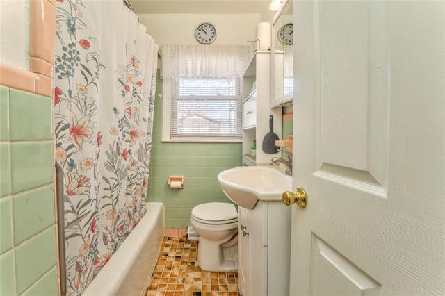 bathroom with tile walls, toilet, shower / tub combo, vanity, and tile patterned floors