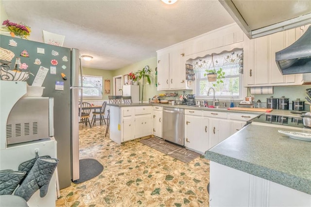 kitchen featuring stainless steel appliances, a healthy amount of sunlight, a peninsula, and under cabinet range hood