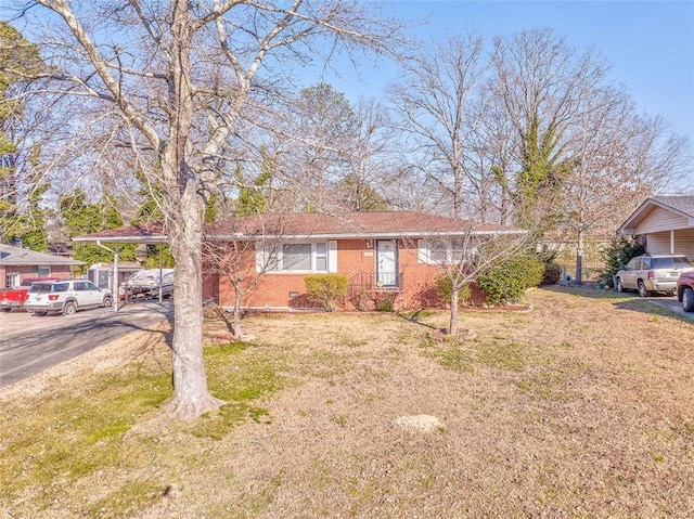 ranch-style house featuring brick siding and a front lawn