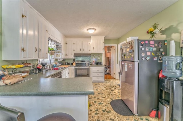 kitchen with appliances with stainless steel finishes, white cabinetry, a sink, and a peninsula