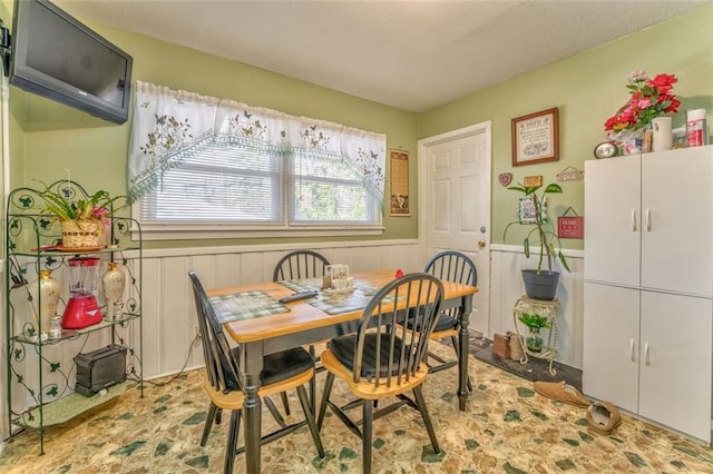 dining area with a wainscoted wall