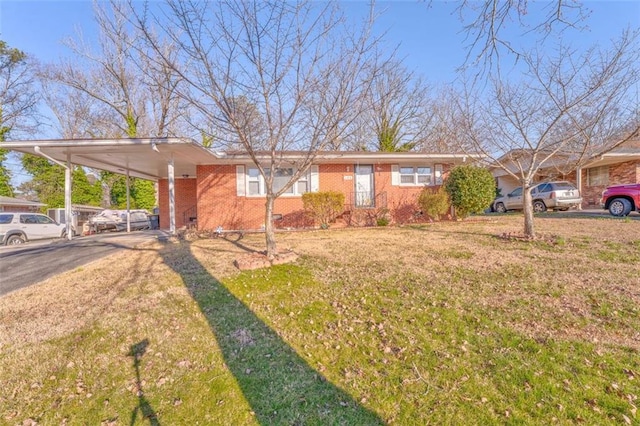 view of front of property featuring concrete driveway, an attached carport, crawl space, a front lawn, and brick siding