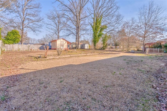 view of yard with fence, an outdoor structure, and a storage shed