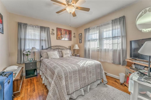 bedroom featuring ceiling fan, baseboards, and wood finished floors