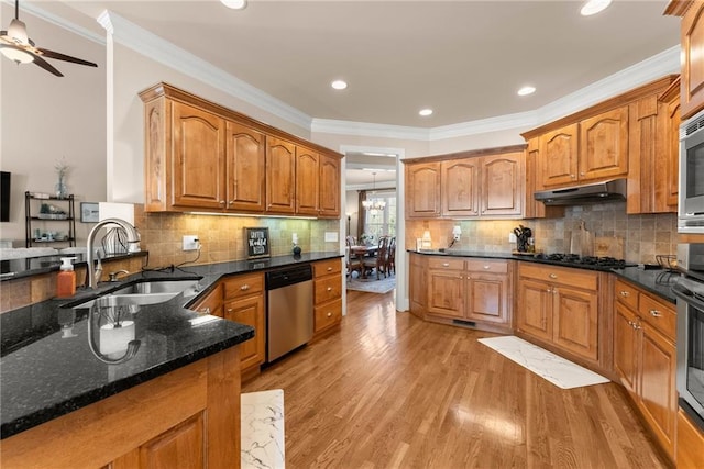 kitchen with sink, dark stone countertops, light wood-type flooring, dishwasher, and black gas stovetop