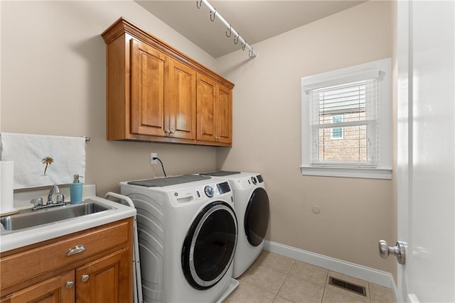 laundry room with light tile patterned flooring, cabinets, separate washer and dryer, and sink