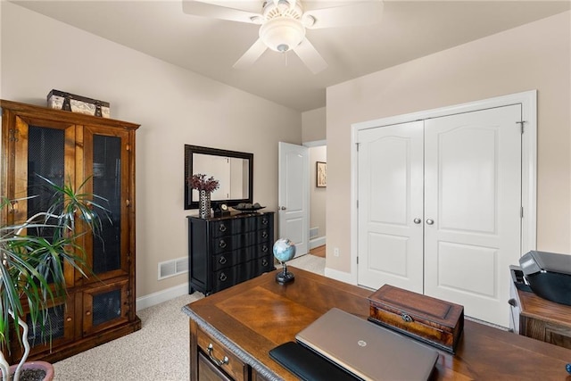 carpeted office space featuring ceiling fan