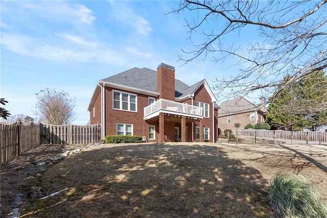 back of house featuring a wooden deck and a lawn