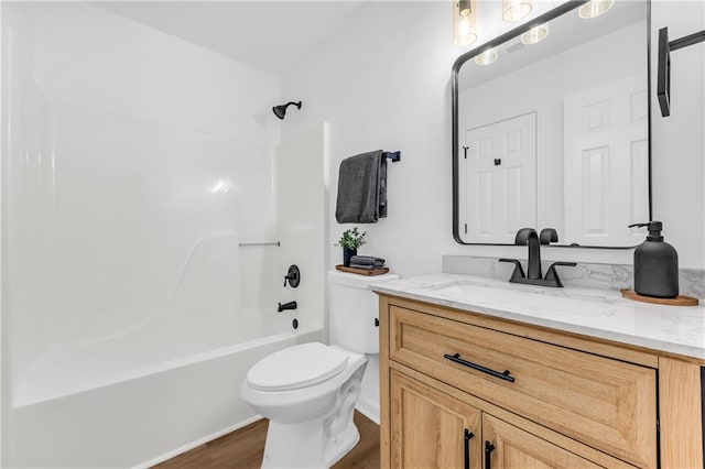 full bathroom featuring hardwood / wood-style flooring, vanity,  shower combination, and toilet