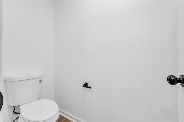 bathroom with hardwood / wood-style flooring and toilet