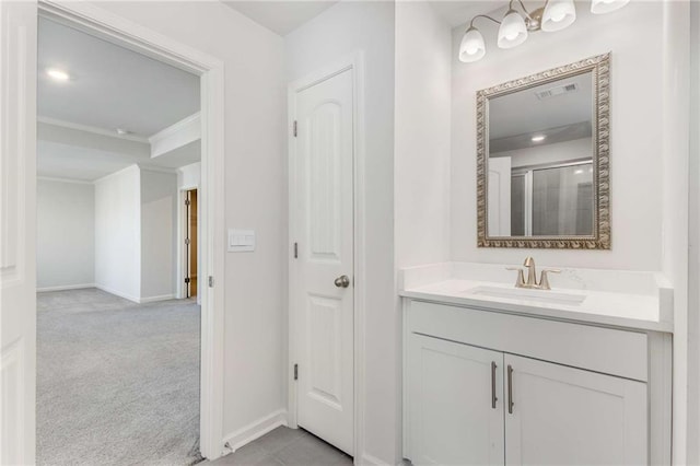 bathroom with vanity, a shower with door, and ornamental molding