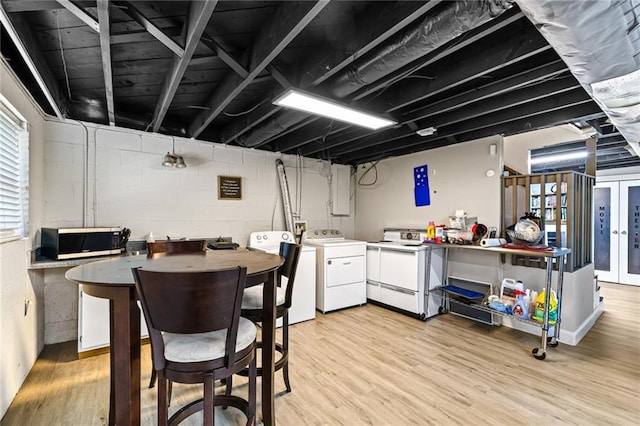 kitchen featuring white cabinetry, washing machine and dryer, light wood-style flooring, and white electric range