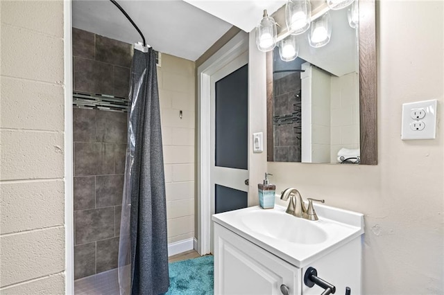 full bathroom with tiled shower and vanity