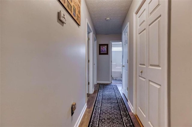 hall featuring a textured ceiling and hardwood / wood-style flooring