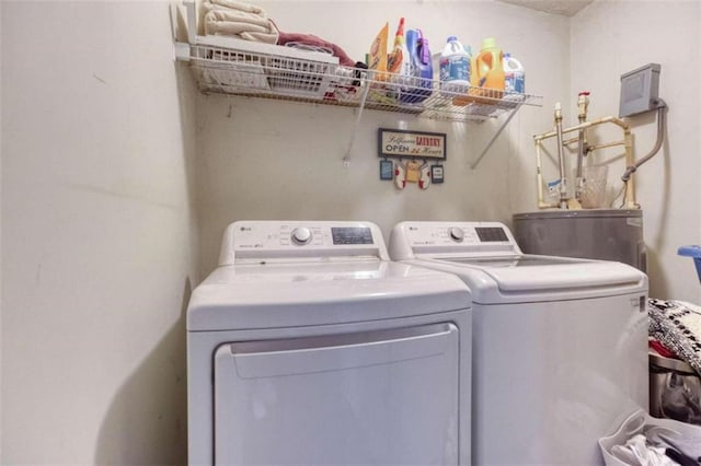 washroom with water heater and washer and clothes dryer