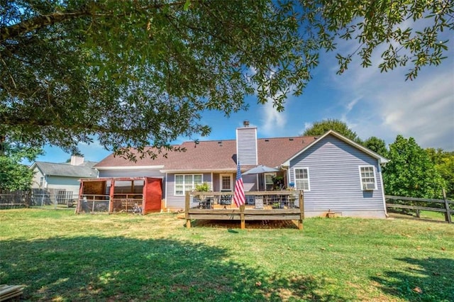 rear view of property featuring a yard and a deck