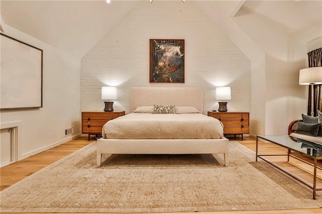 bedroom with hardwood / wood-style floors and lofted ceiling