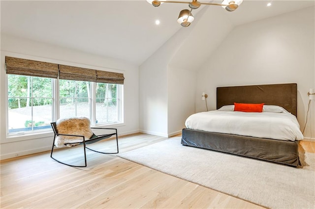 bedroom with light wood-type flooring and vaulted ceiling