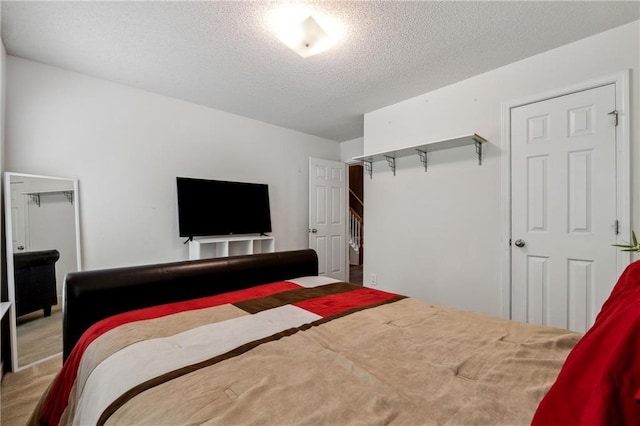 bedroom with a textured ceiling, carpet floors, and a closet