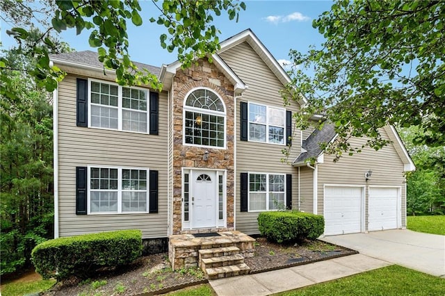 colonial inspired home featuring stone siding, driveway, and an attached garage