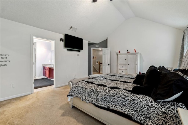 bedroom with lofted ceiling, light carpet, visible vents, baseboards, and ensuite bath