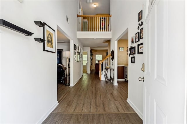 entryway with dark wood-style flooring, visible vents, stairway, and baseboards