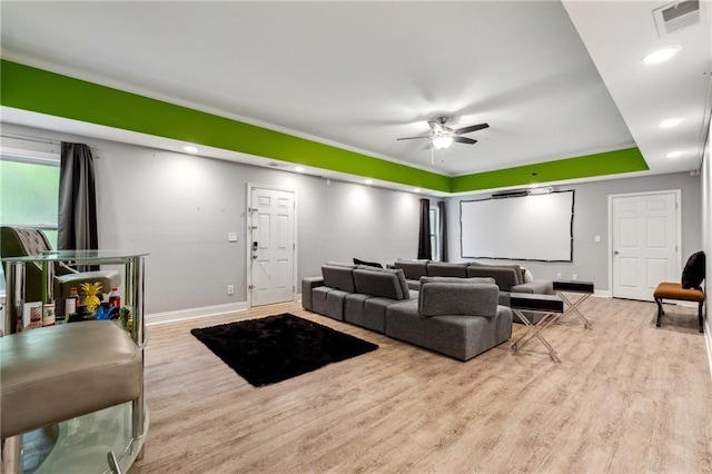 living room featuring light wood-style flooring, visible vents, ceiling fan, and baseboards