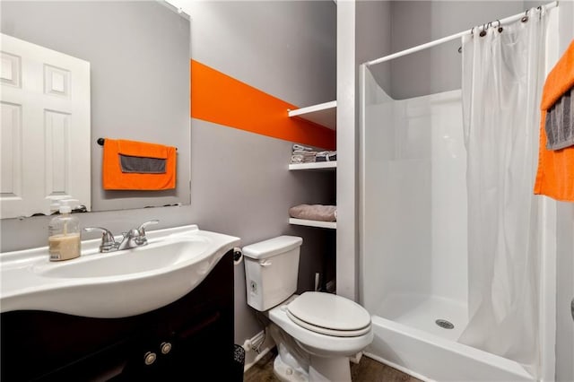 bathroom with toilet, a stall shower, and vanity