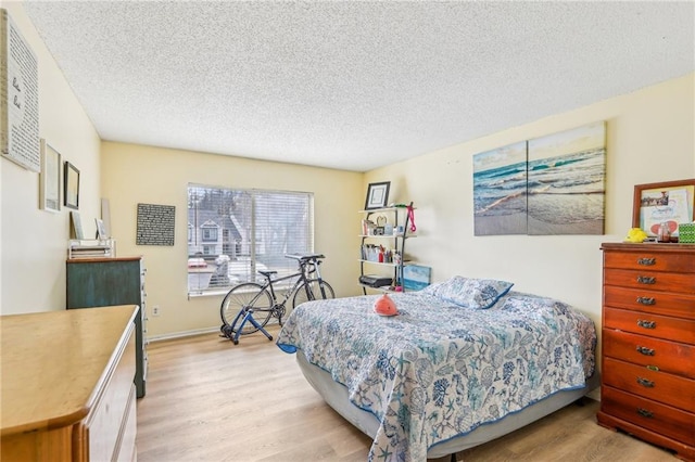 bedroom with light hardwood / wood-style floors and a textured ceiling