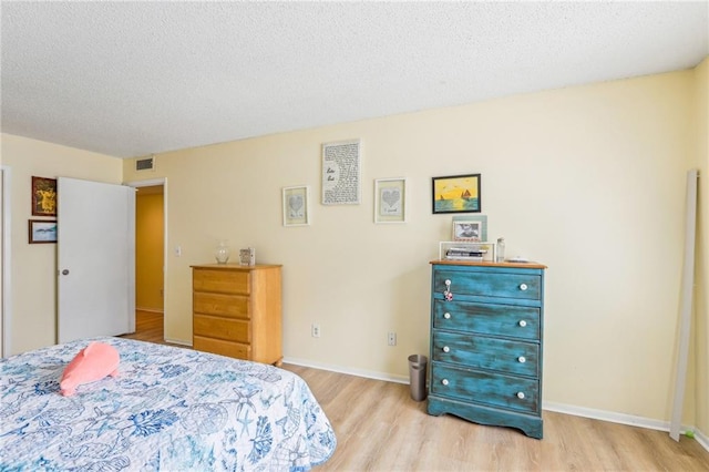 bedroom featuring a textured ceiling and light wood-type flooring